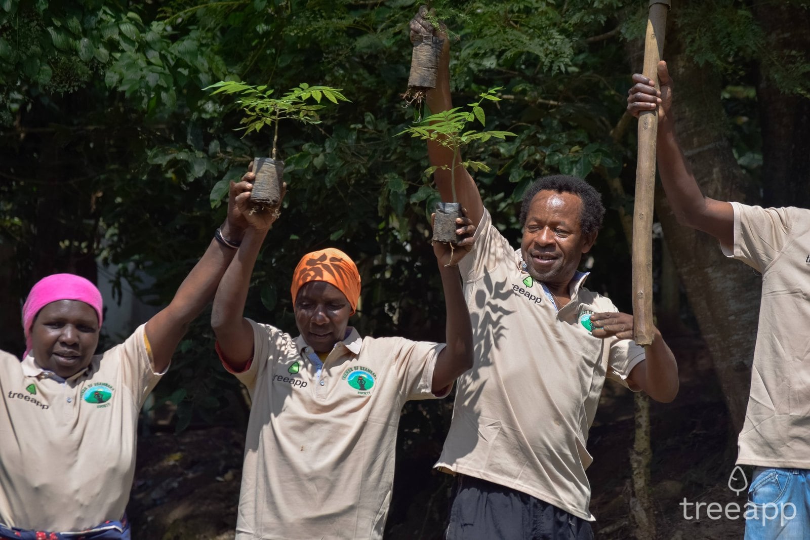A Treeapp planting team holding saplings in Tanzania
